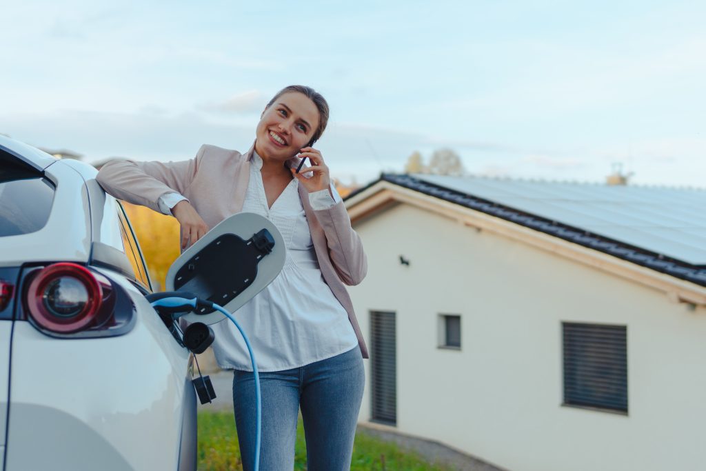 woman using solar power to charge her electric vehicle